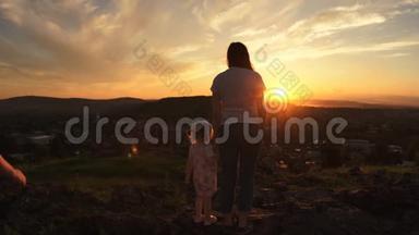 一个夏天的晚上，一家人正站在日落的山上。